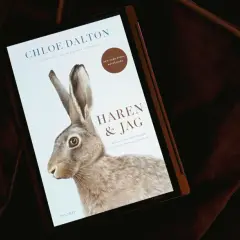 En bok med titeln "Haren & Jag" visas på en skärm, med en illustration av en hare. Boken handlar om en oväntad vänskap, som en hare boplats i naturen.