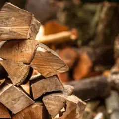 En stapel huggen ved, redo att ge värme. Vedens energivärde är högt, perfekt för kalla vinterdagar.