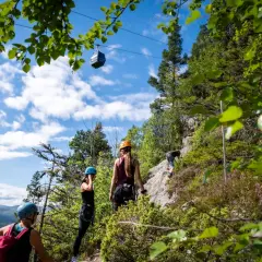 Äventyr vid Ramundberget: klättrare på klippvägg, linbana i skyn, en perfekt dag för vandring och utmaningar.