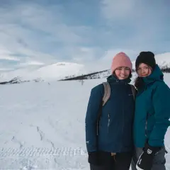 Två glada vandrare på vintern i snöklädda fjäll.