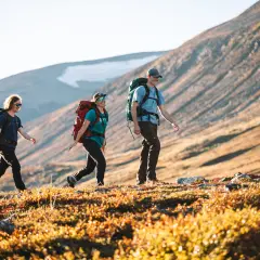 Vandrare njuter av solnedgången i fjällen nära STF Kvikkjokk.