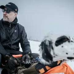 Man med hund i snölandskap, kanske på en resa genom girjas sameby.