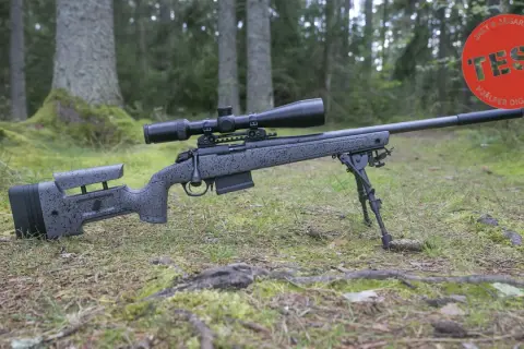 En prickskyttegevär med kikarsikte och bipod ligger i skogen. Artikeln handlar om vad man får jaga med 22lr.