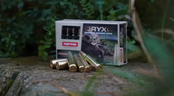 Norma Oryx ammunition, med olika vapen namn på förpackningen, ligger utspridda på en sten.