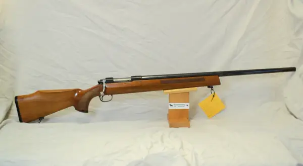 En klassisk Tikka M55 i trä, redo för jakt.