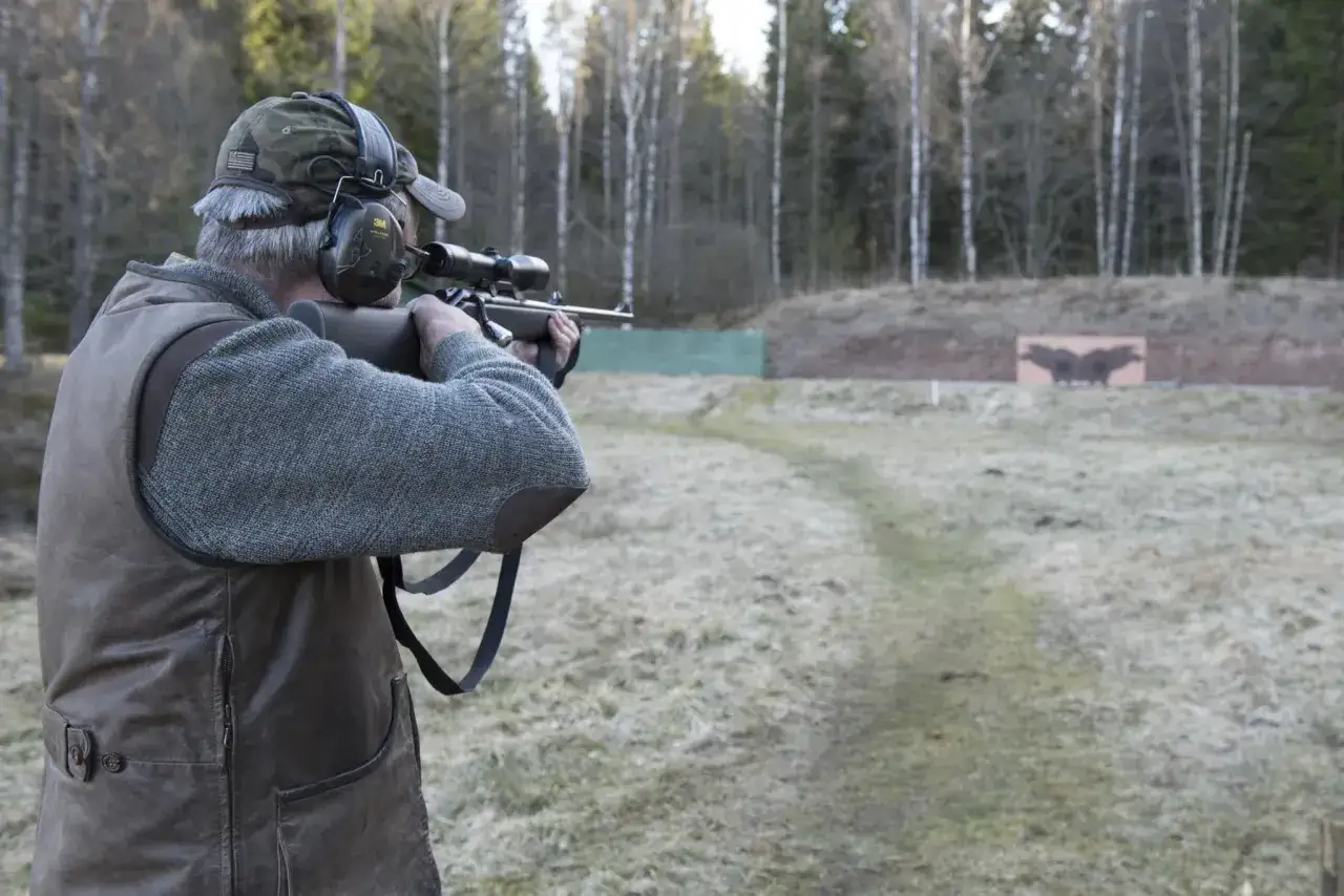 Man övar skytte med ett 22lr-gevär på en skjutbana. Frågan om vad man får jaga med 22lr är relevant för många jägare.
