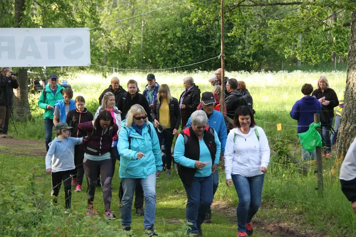 Grupp människor på en nattvandring Kinnekulle. En vit banderoll med texten