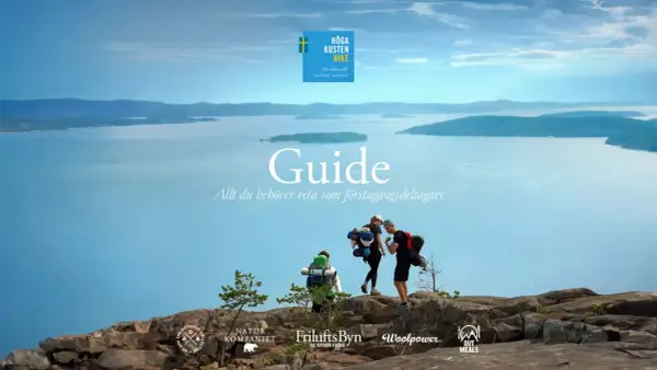 Vandrare på en klippa med havet och öar i bakgrunden, en guide för Höga Kusten Hike.