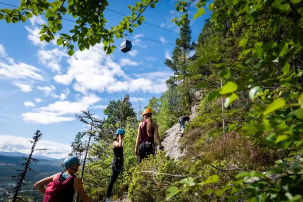Äventyr vid Ramundberget: klättrare på klippvägg, linbana i skyn, en perfekt dag för vandring och utmaningar.