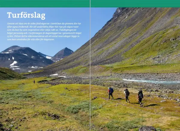 Vandrare med ryggsäckar rör sig genom ett gräsbevuxet landskap i Sarek nationalpark, med berg och en flod i bakgrunden.