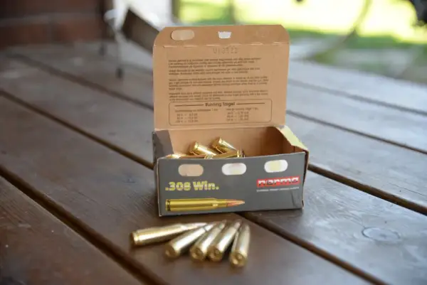 En öppen ask med .308 Win. ammunition på ett träbord. Texten på asken ger information om hur mycket ammunition man får ha hemma och dess användning.